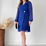 Elegant black pleated mini dress featuring long sleeves, ideal for an office chic look, with a focus on shoulder and waist design elements.