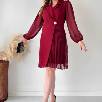 Elegant black pleated long sleeve mini dress with a fitted waist and knee-length hem, designed for an office chic look.