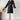 Elegant black pleated long sleeve mini dress styled with chic office wear, featuring a model wearing black footwear. The dress is a one-piece garment with a knee-length hem, suitable for a professional setting.