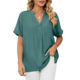 Woman wearing an elegant dark green V-neck linen blouse with short sleeves, showcasing casual summer style.