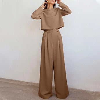 Elegant black wide-leg palazzo jumpsuit featuring long sleeves, high waist, and boat neck collar.
