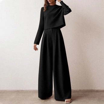 Elegant black wide-leg palazzo jumpsuit with long sleeves, high waist, and boat neck.