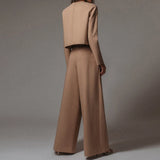 Elegant black wide-leg palazzo jumpsuit with long sleeves, high waist, and boat neck design.