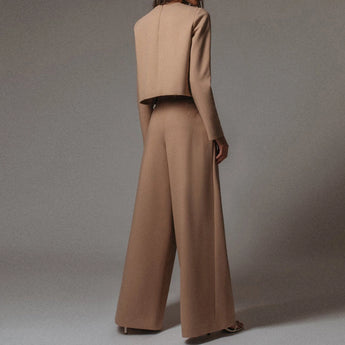 Elegant black wide-leg palazzo jumpsuit with long sleeves, high waist, and boat neck design.