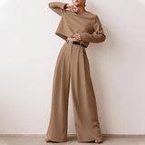 Elegant black wide-leg palazzo jumpsuit with long sleeves, high waist, and boat neck, shown in a khaki color, size 2XL.