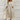 
An elegant blue lace top evening dress featuring a high-low skirt. The dress is in a beige color and is available in a 3XL size. The design includes intricate lace detailing on the shoulders and neckline, with long sleeves and a defined waist.