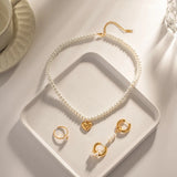 Elegant bridal pearl choker necklace with gold heart charm on a white background.
