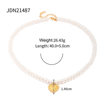 Elegant bridal pearl choker with gold heart charm and gold leaf detailing, displayed against a neutral background to highlight its intricate design and romantic appeal.