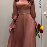Elegant copper satin evening gown featuring a belted waist and puffed sleeves, highlighting its sophisticated design.