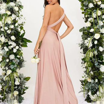 Elegant cream backless evening gown with a bow, suitable for wedding guests, featuring a strapless design and a fitted waist.