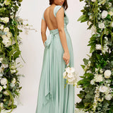 Elegant cream backless evening gown with a bow, featuring a one-piece design, shoulder detailing, and floral embellishments.