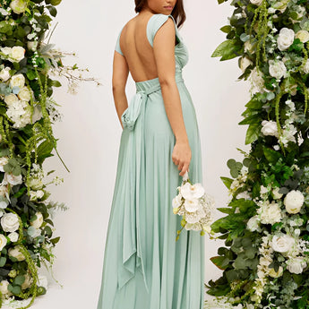 Elegant cream backless evening gown with a bow, featuring a one-piece design, shoulder detailing, and floral embellishments.
