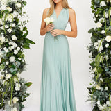 Elegant cream backless evening gown with a bow, featuring a light mint green color, modeled by a woman with styled hair, showcasing the dress's one-piece design, shoulder details, and floral accents.