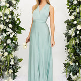 Elegant cream backless evening gown with a large bow at the back, worn by a woman with styled hair, showcasing her shoulders and arms. The dress features a sleek design, suitable for a wedding guest.