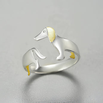 Elegant silver ring with gold accents featuring dog-themed design, perfect for pet lovers.