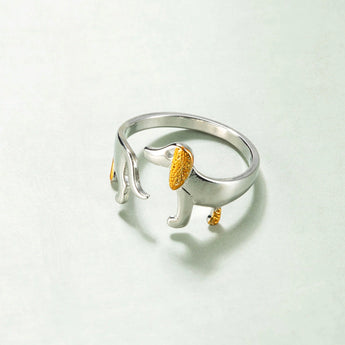 Elegant dog-themed silver ring with gold accents, featuring intricate design elements and a gemstone centerpiece, perfect for pet lovers.