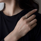 Elegant dog-themed silver ring with gold accents worn on a finger.