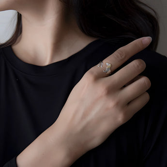 Elegant dog-themed silver ring with gold accents worn on a finger.