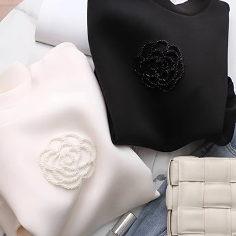 Elegant white women's sweatshirt featuring intricate floral embroidery, displaying long sleeves and a classic round collar.
