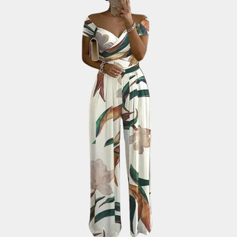 Elegant off-shoulder denim jumpsuit with a white leaves pattern in 3XL size, featuring a fitted waist, short sleeves, and thigh-length design for a fashionable and luxurious look.