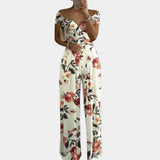 Elegant floral off-shoulder denim jumpsuit featuring white flower patterns, designed for women's luxury wear in size 3XL. The jumpsuit showcases a stylish one-piece garment with a fashionable design, emphasizing the waist and sleeves, suitable for both formal and day wear occasions.