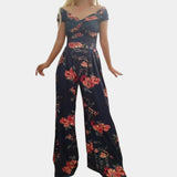 Elegant floral off-shoulder denim jumpsuit in dark blue, showcasing a luxurious women's one-piece garment with a focus on the shoulder and neck area, highlighting the stylish design and textile details.