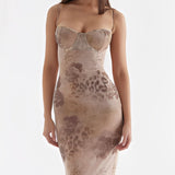 Elegant floral velvet gown with sleeveless design and criss-cross back, highlighting the human form with a focus on the neck, waist, and legs.