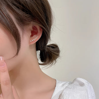 Woman wearing elegant gold chain drop earrings with crystal star charms, showcasing facial features like forehead, nose, lips, chin, eyebrows, eyelashes, ears, neck, and jaw.