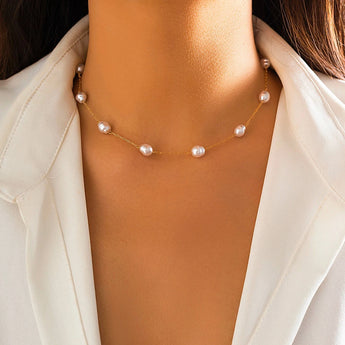 Elegant gold chain pearl necklace worn around the neck of a model dressed in beige outerwear, highlighting the necklace as a perfect bridal gift or accessory for her.