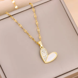 Elegant gold chain necklace with a white enamel heart-shaped pendant adorned with rhinestones.