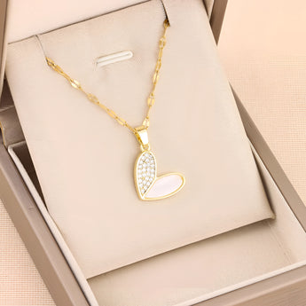Elegant gold chain necklace with a white enamel heart-shaped pendant adorned with rhinestones.