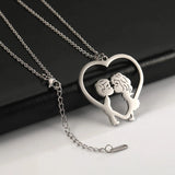 A hand holding an elegant gold heart-shaped couple necklace with a delicate chain, perfect as a romantic anniversary gift.