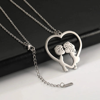 A hand holding an elegant gold heart-shaped couple necklace with a delicate chain, perfect as a romantic anniversary gift.