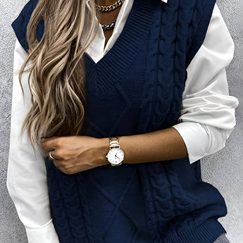 Men's sleeveless wool sweater vest in elegant gray with a cable knit pattern, shown on a mannequin. The vest is styled over a dress shirt, highlighting its V-neck design.