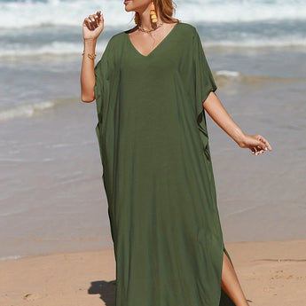 Elegant green V-neck caftan, lightweight and flowy beach dress, worn by a person standing on the beach.