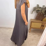 Elegant grey pleated midi dress with side cut-outs, featuring short sleeves, a fitted waist, and a knee-length skirt, suitable for daytime wear.