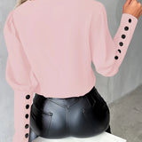 
A stylish light pink blouse for women featuring buttoned sleeves, showcasing the shoulder and neck area against a neutral background.
