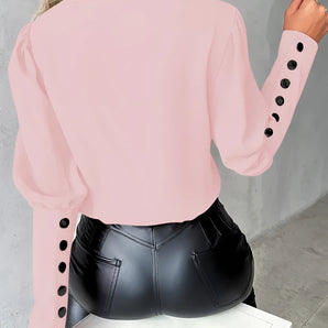 
A stylish light pink blouse for women featuring buttoned sleeves, showcasing the shoulder and neck area against a neutral background.