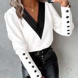 
A women's elegant white blouse featuring buttoned sleeves, designed in a dress shirt style, suitable for formal or casual occasions.