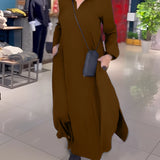 Elegant long black maxi dress featuring a high collar and pockets, displayed in a sophisticated setting.