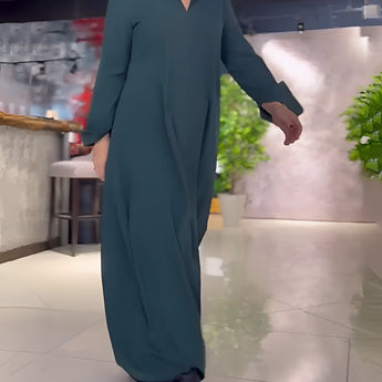 Elegant long black maxi dress featuring a high collar and convenient pockets, designed with long sleeves and a flattering waistline.