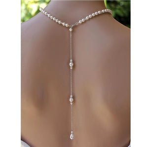 Elegant long pearl bridal back-drop necklace draped on a model's neck and upper back, showcasing delicate pearls and intricate metalwork, perfect for wedding jewelry.