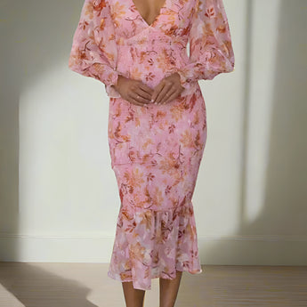 Elegant pink floral maxi dress with long sleeves, featuring a fitted waist and stylish design, modeled by a fashion model.