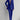 
A woman modeling an elegant blue tailored blazer and trouser set, featuring a structured shoulder and classic collar, suitable for formal or business occasions. The ensemble is designed with attention to detail, emphasizing the waist for a flattering fit.