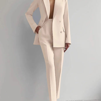 Elegant pink women's suit consisting of a tailored blazer and trouser set, featuring a beige color. The blazer has a structured collar and long sleeves, and the model is standing.