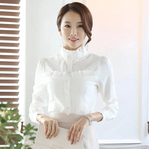 Elegant ruffled Victorian blouse in white, featuring a high neck and long sleeves, designed as luxury office wear in size XL. The blouse has intricate detailing around the neck and shoulders, showcasing a classic fashion design.