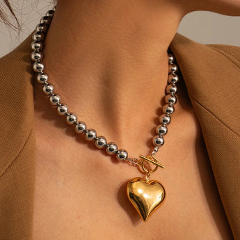 Elegant silver and gold heart charm bracelet with intricate chain, perfect romantic jewelry gift.