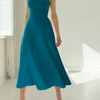 Elegant teal midi dress with a sleeveless fit and flare design, perfect for formal events, displayed on a mannequin near a window.
