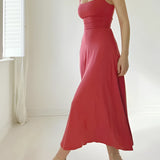 Elegant teal midi dress in a sleeveless fit and flare style, displayed against a window backdrop, showcasing its formal design, fitted waist, and flowing skirt.