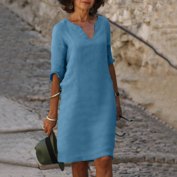 Elegant V-neck black dress with 3/4 sleeves, knee-length design, suitable for business casual settings, shown in Azzurro color and size 3XL. The dress is displayed on a standing mannequin, highlighting its fit at the waist and tailored knee-length.